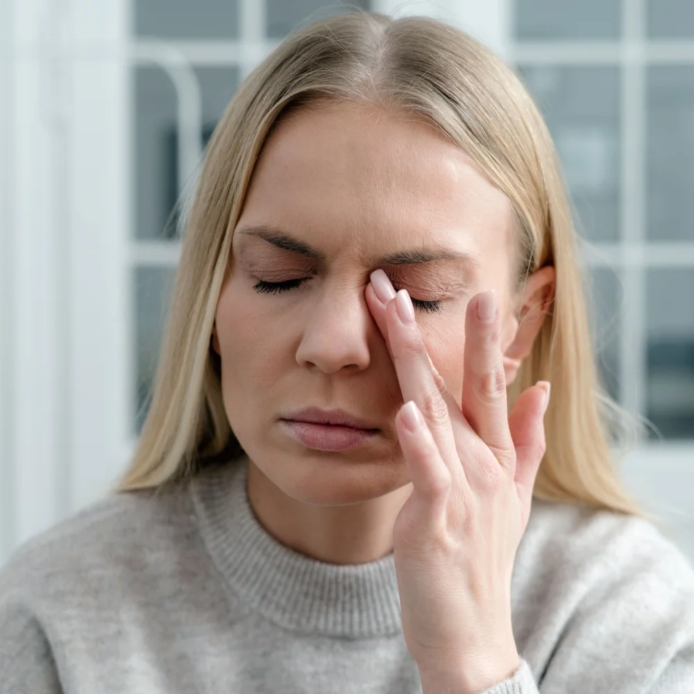 woman rubbing her irritated dry eyes