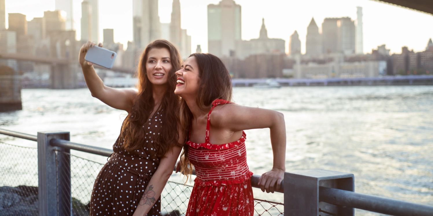 two women taking a selfie on a bridge