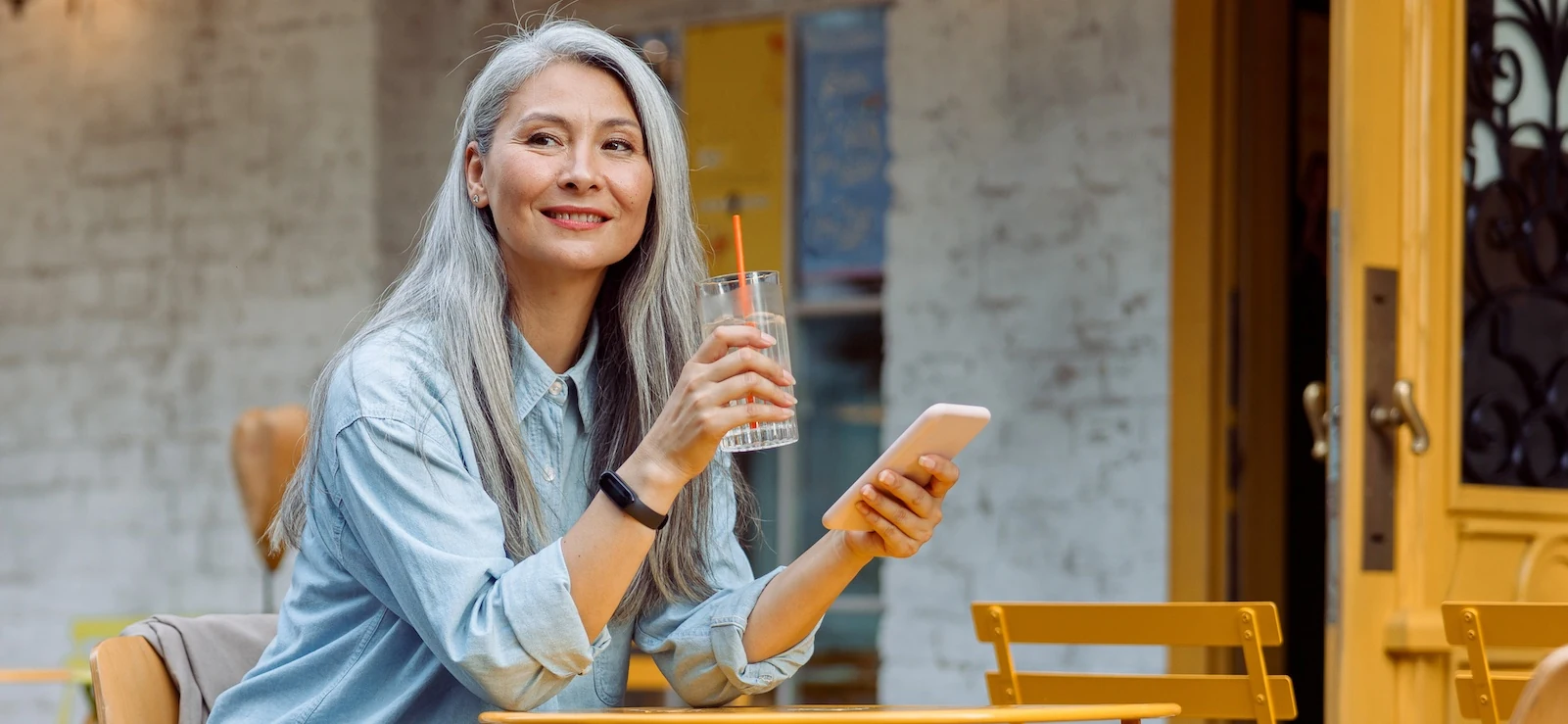 mature woman enjoying clear vision and reading her phone while at the cafe